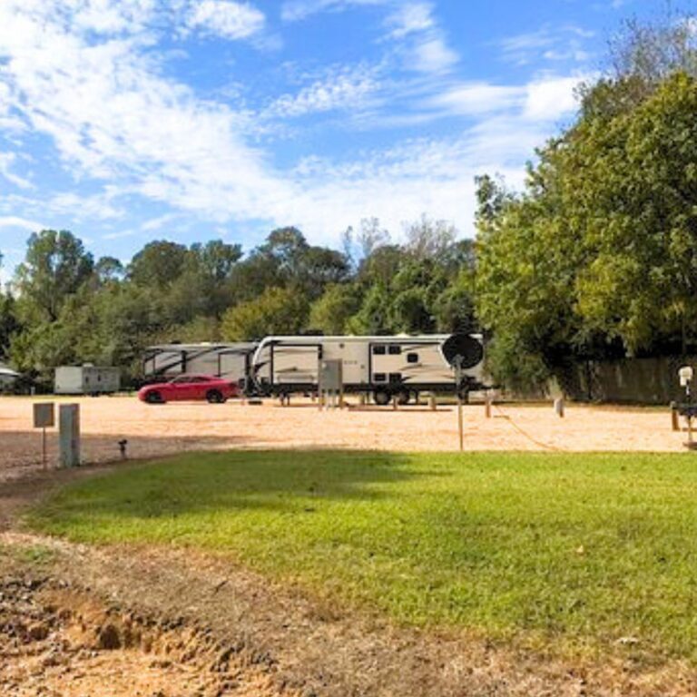 Two RVs parked outside at Bayou Creek RV Park