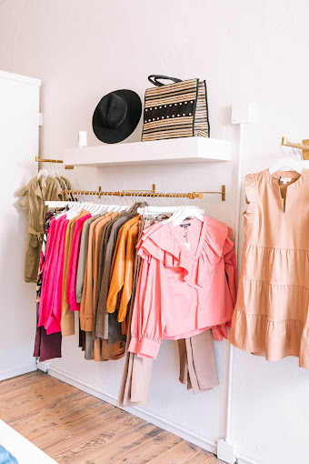 A clothing display of pink and salmon colored women's clothing at NK boutique