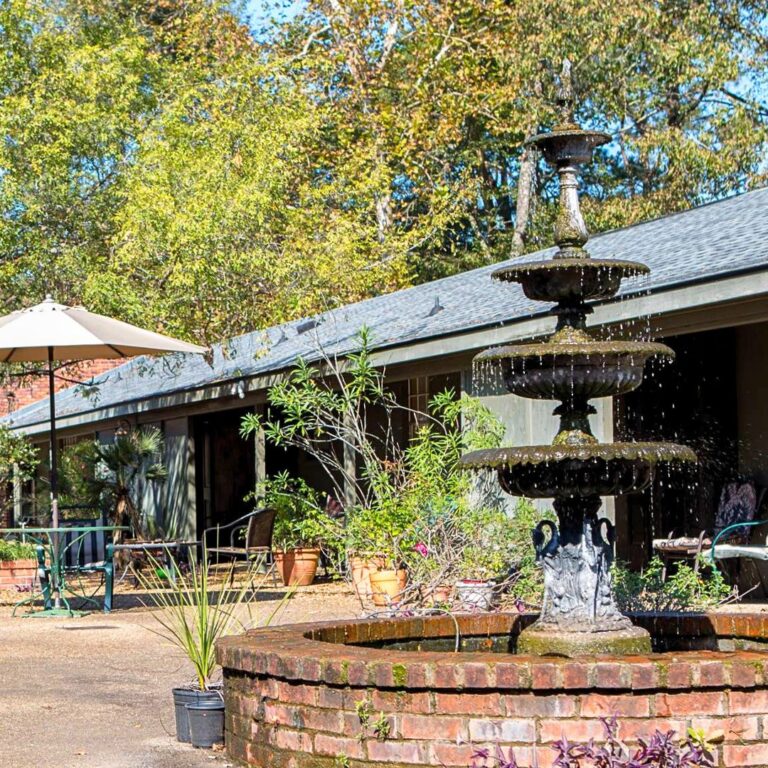 An outdoor courtyard setting at the Lamplighter Suites featuring a fountain.